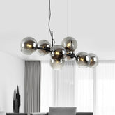 A modern chandelier with multiple smoked gray glass globes arranged on a black frame, suspended from a black cord.