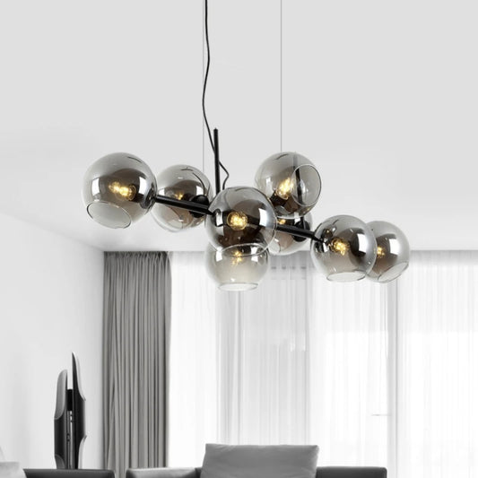 A modern chandelier with multiple smoked gray glass globes arranged on a black frame, suspended from a black cord.