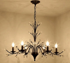 Decorative chandelier hanging from a ceiling with a beige wall background