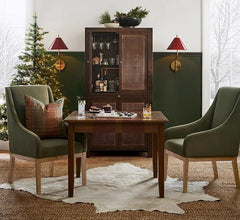 Living room with green walls, a wooden cabinet, and two green chairs with plaid cushions.
