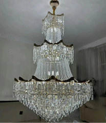 Large crystal chandelier hanging from a ceiling in a room with a sofa.