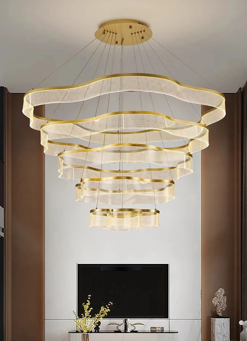 Modern chandelier with gold accents in a living room setting.