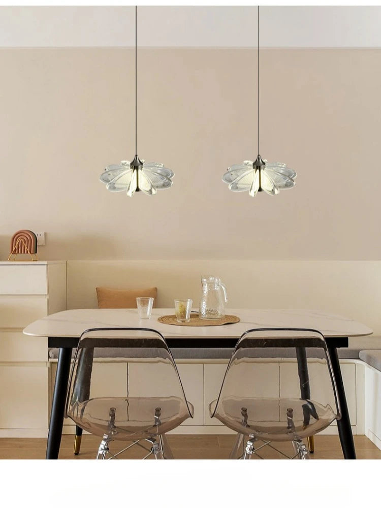 Dining area with a table, chairs, and pendant lights in a modern interior setting.