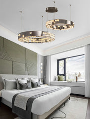 Modern bedroom with stylish chandeliers, bed, and large window.