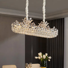 Polished chrome linear chandelier with crystal floral accents, suspended over a dining table.