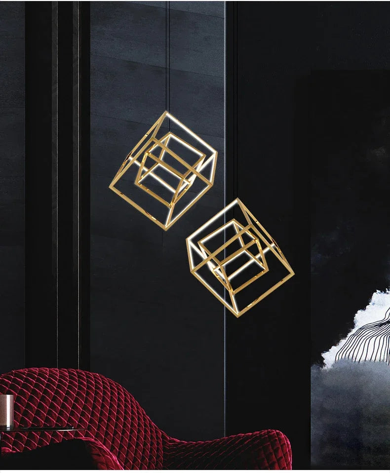 Gold geometric wall art pieces on a dark wall with a red chair in the foreground.
