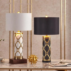 Two table lamps with decorative bases on a marble surface.