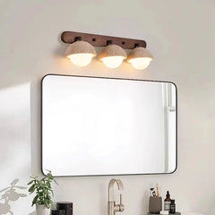 Bathroom mirror with three light fixtures above it, on a white wall.