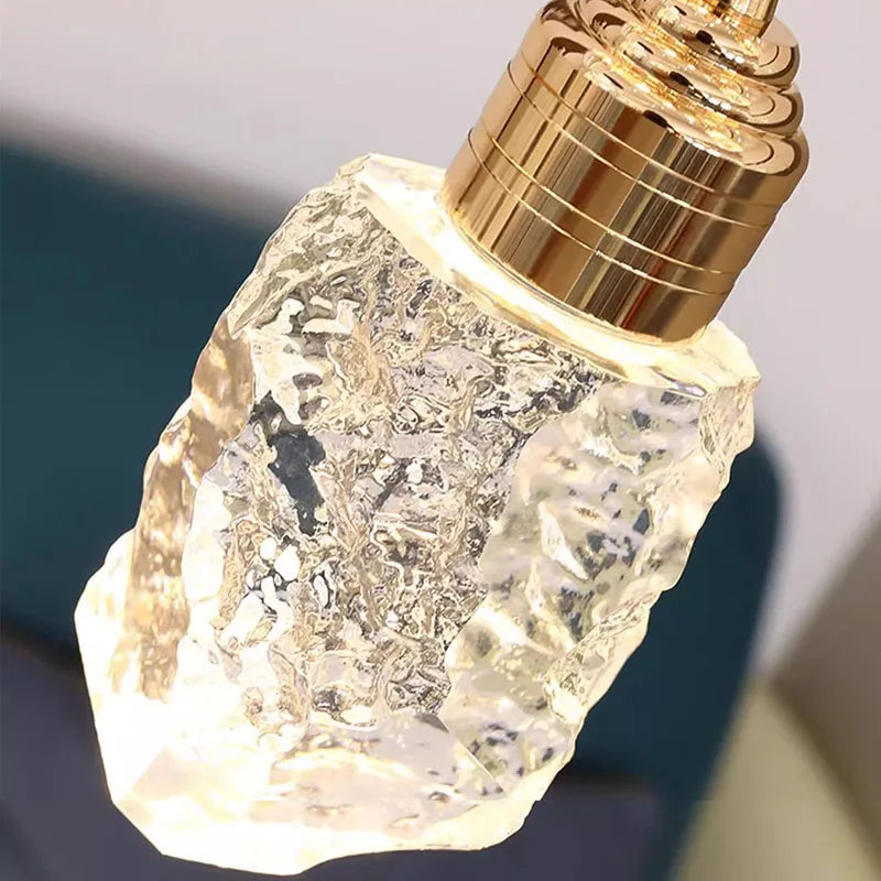 Decorative light bulb with a gold base and textured clear glass body on a dark background