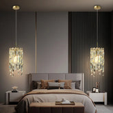 Gold tiered crystal pendant light hanging above a bed