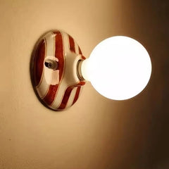 Close-up of the ceramic wall sconce base with brown and white stripes.