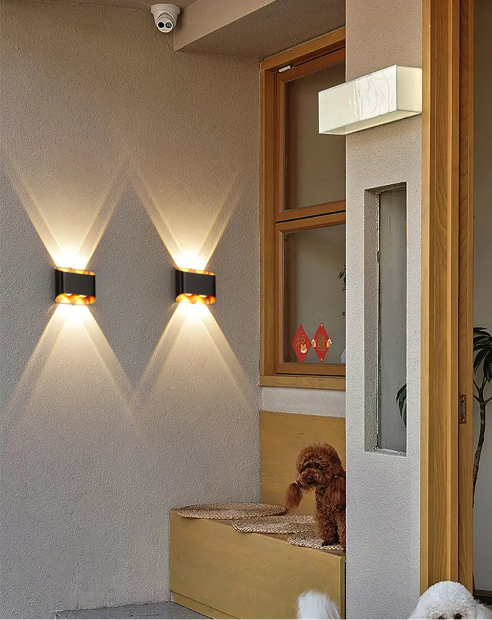 Wall-mounted lights on a wall with a dog sitting on a mat in the background.