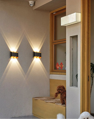 Wall-mounted lights on a wall with a dog sitting on a mat in the background.