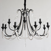 A black, multi-arm chandelier adorned with strings of white pearl-like beads and clear crystal teardrops, featuring candelabra-style light sockets against a plain white background.
