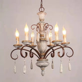 Distressed white wood chandelier with candle-style lights and decorative crystal drops, shown against a light gray background.