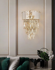 Decorative wall sconce with crystal details on a wall with decorative molding.