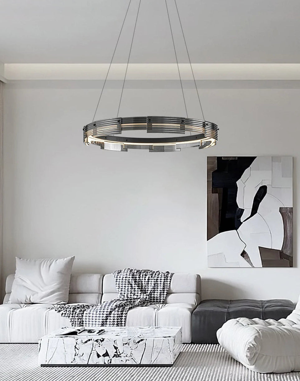 Modern living room with a chandelier, sofa, and abstract painting.