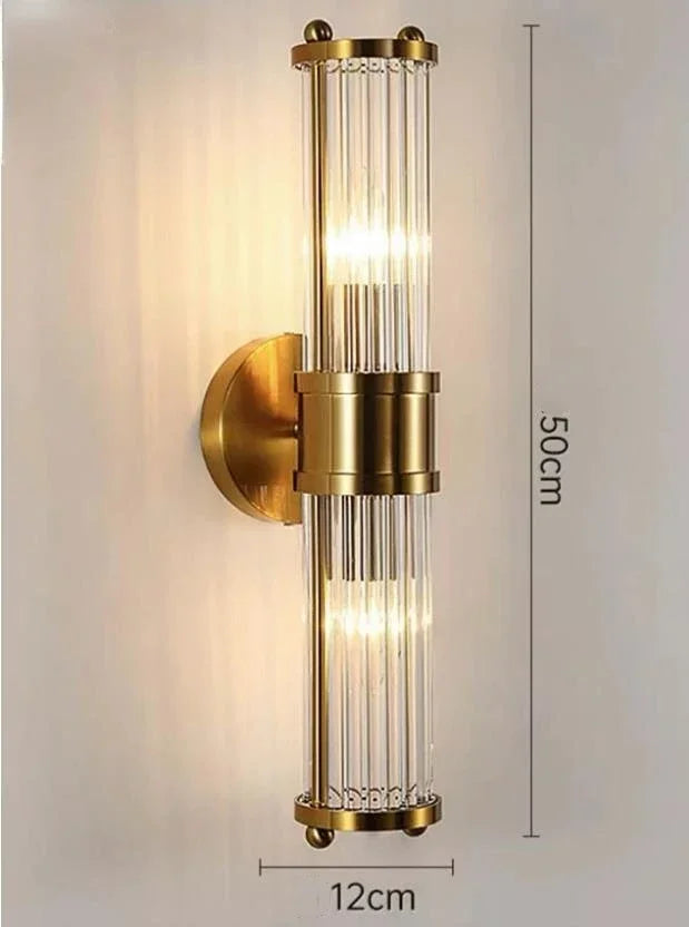 Wall-mounted lamp with gold finish and clear glass cylinder, dimensions indicated.