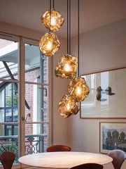Modern dining room with gold pendant lights and large windows.