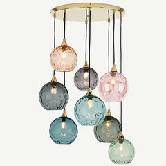 Cluster of colorful textured glass globe pendant lights with a polished gold canopy