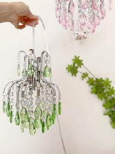 Small decorative chandelier with green crystals on a white background