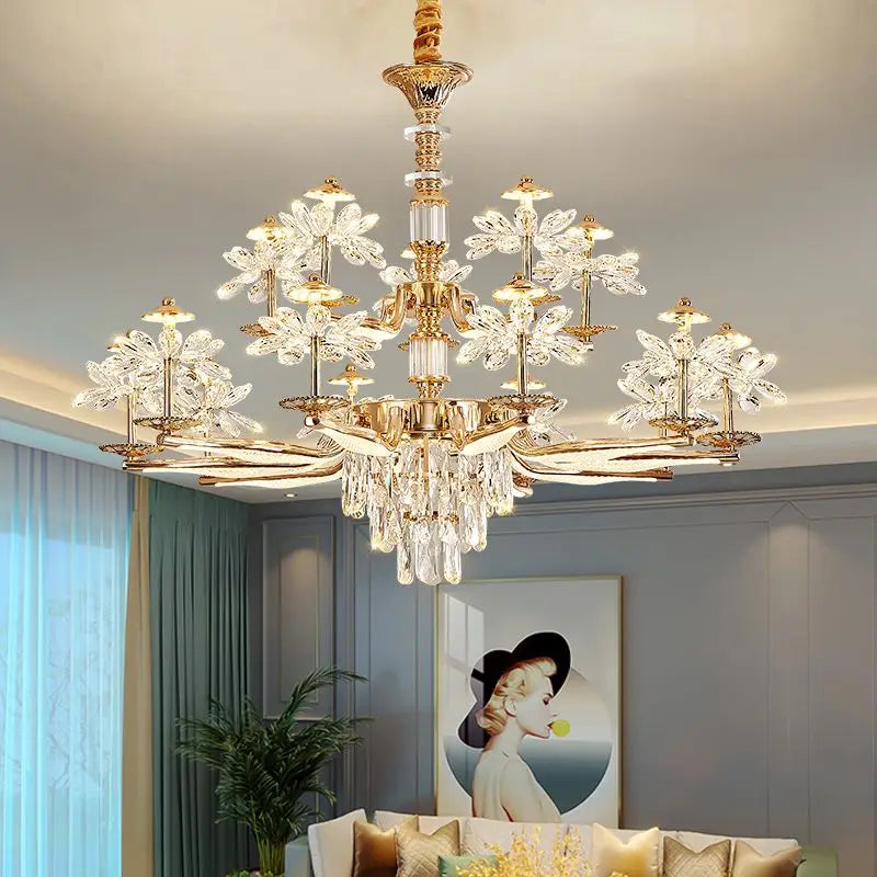 A wide shot of a gold chandelier with crystal flower accents and cascading teardrop crystals illuminating a living room.
