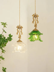 Two pendant lights with gold fixtures and green glass shades on a white background.