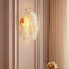 Wall-mounted light fixture with feather design on a striped wall.