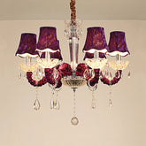 A luxurious 6-head chandelier with purple fabric shades and cascading crystal droplets, featuring a chrome-finished multi-arm structure.