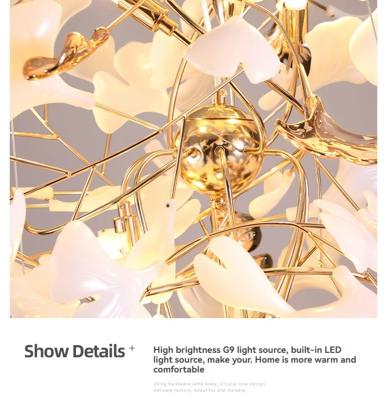 Gold chandelier with white floral accents on a light gray background