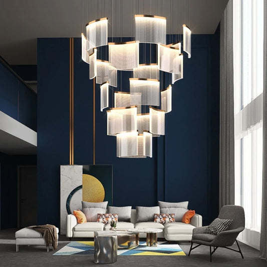 Gold cascading crystal waterfall chandelier installed in a modern living room with a high ceiling.