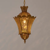 A gold hollow carved floral pendant light casting intricate shadows on a wall.
