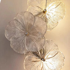 Decorative wall lights shaped like flowers on a beige wall.
