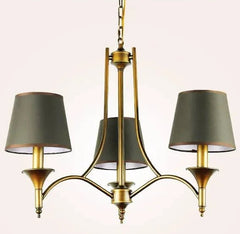 Chandelier with three green lampshades on a light pink background