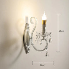 Decorative wall sconce with crystal details on a plain wall, showing dimensions.