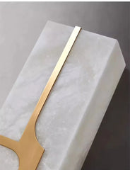 Gold candelabra on a marble base against a gray background