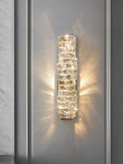 Decorative wall sconce with crystal-like design on a neutral wall.