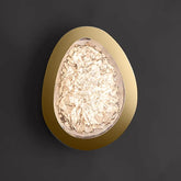 Gold textured resin egg-shaped wall sconce mounted on a dark gray wall, lit from within.