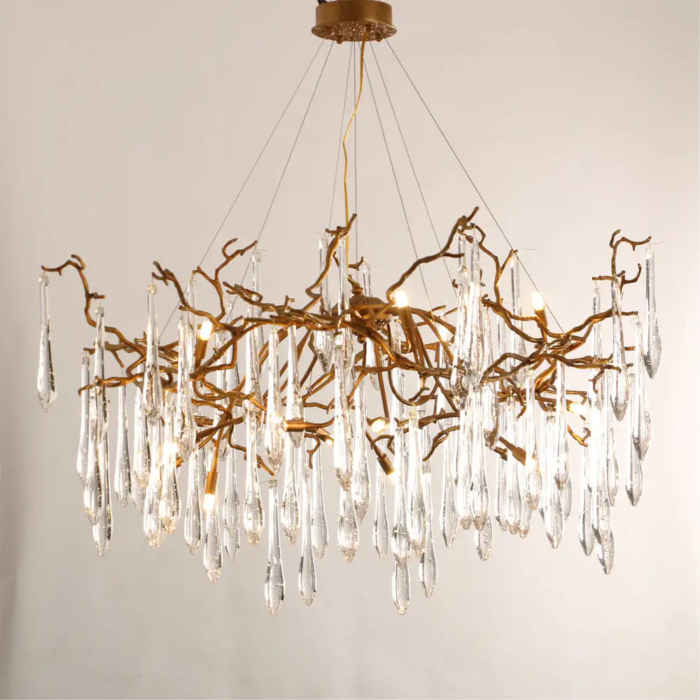 Chandelier with gold branches and clear crystal elements on a neutral background