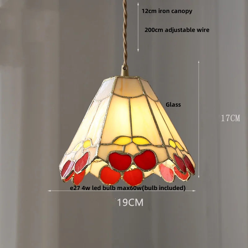 Stained glass pendant light with decorative design on a gray background