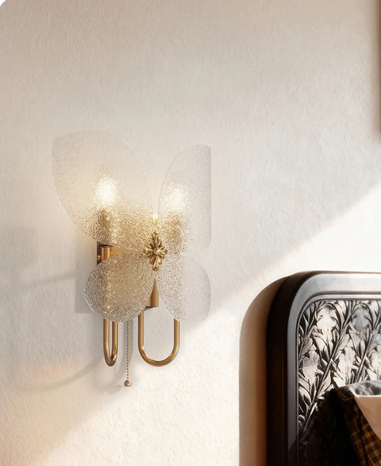 Decorative wall sconce with a textured glass shade on a neutral wall.