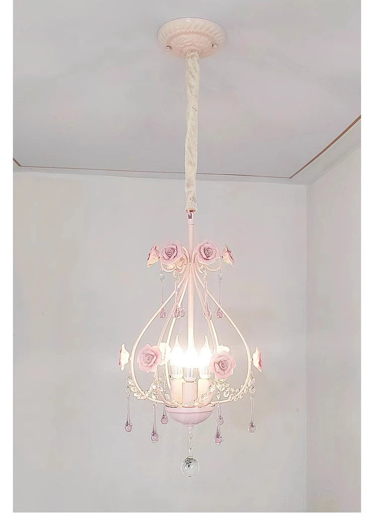 Close-up view of the pink crystal chandelier with rose details and hanging prisms.