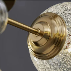 Close-up of a gold fixture with a textured glass shade on a dark background