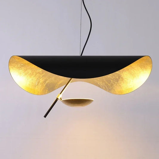 A black and gold leaf pendant light with a wavy design, suspended against a neutral background.