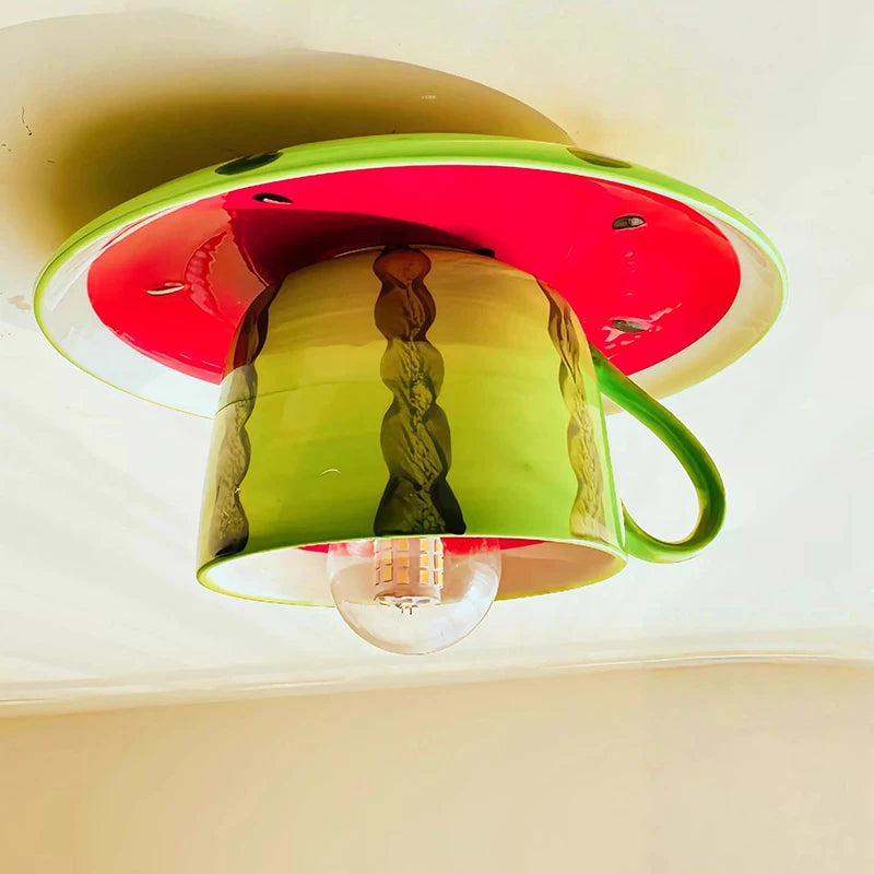 Detailed view of the green watermelon ceramic coffee cup ceiling light, showing the texture and design of the watermelon rind and cup, with the LED bulb illuminated.