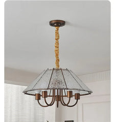 A brushed gold pendant light with a conical frosted glass shade, revealing its internal structure and light sources.