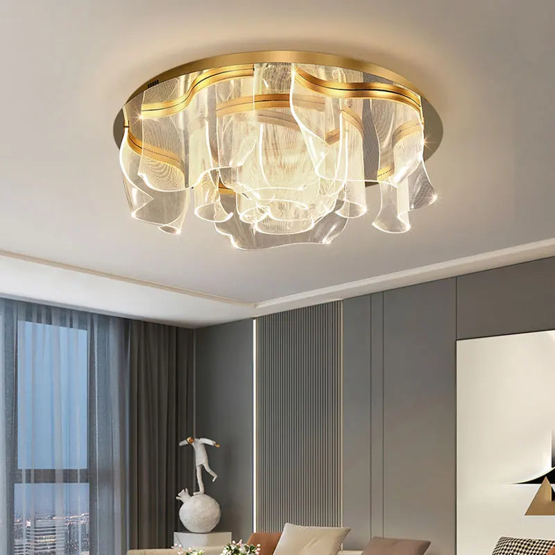 Gold floral wave LED ceiling light with acrylic diffusers mounted on a white ceiling in a modern living room.