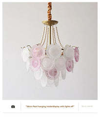 Decorative chandelier with pink and white glass elements on a plain background
