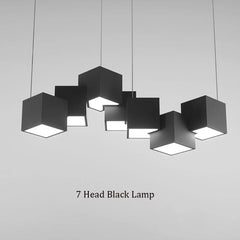 Black pendant lamp with seven cube-shaped lights on a gray background