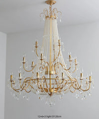 Gold chandelier with crystal accents on a gray wall background